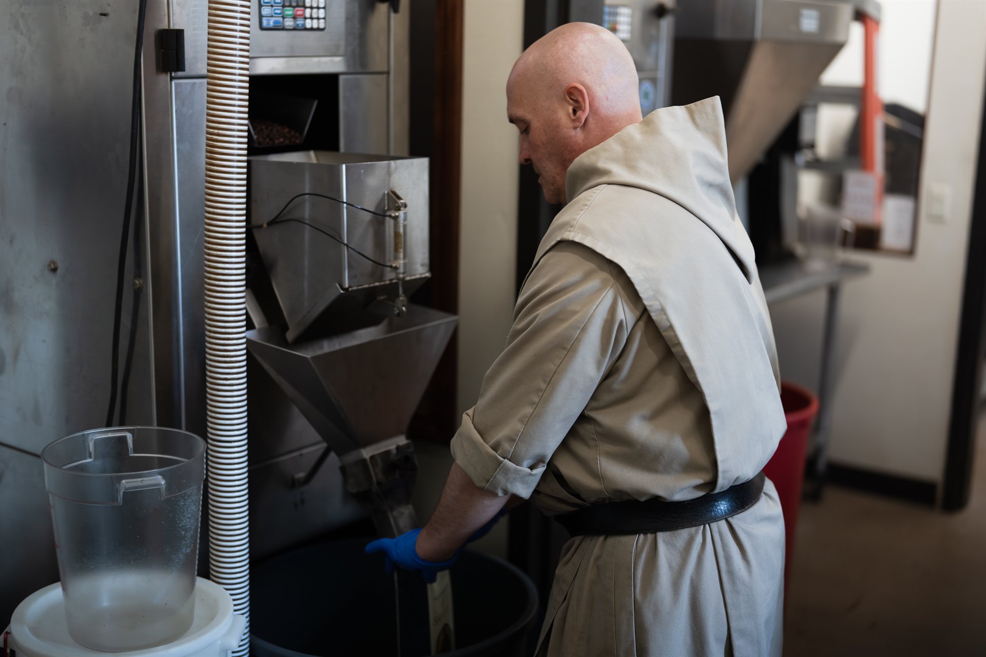 Benedictine monk operating the Sanctus Coffee roasting equipment