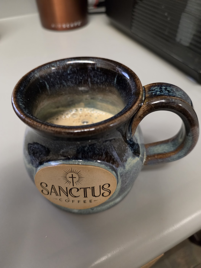 Top-down view of 12 oz Sanctus stoneware mug with freshly brewed coffee and rich golden crema